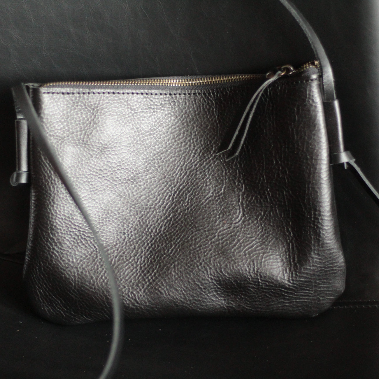 Torba na ramię z regulowanym, skórzanym paskiem do noszenia crossbody.

