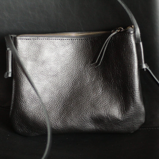 Torba na ramię z regulowanym, skórzanym paskiem do noszenia crossbody.

